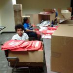 Two young people working on stuffing State Fair Bags for MSCOD