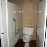 Undersized restroom stall with inswing door and no rear grab bar