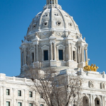 Minnesota State Capitol building with a bright blue sky in the background.